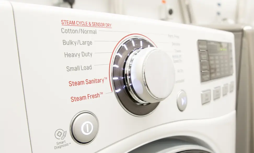A control panel shows cycle options on the front control panel of a white dryer