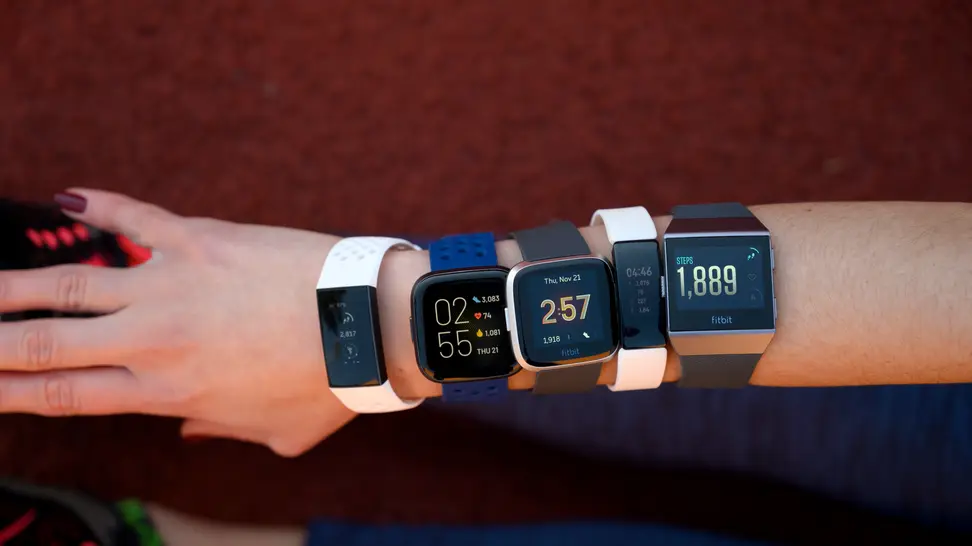 Five different Fitbits worn on a woman's arm