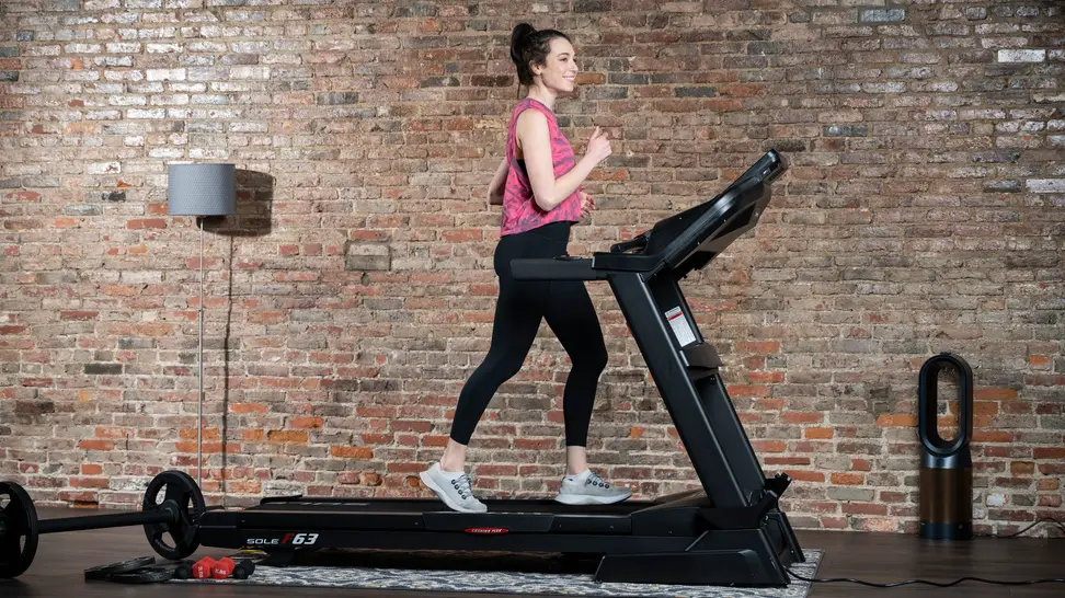 A woman uses a treadmill for a home gym.