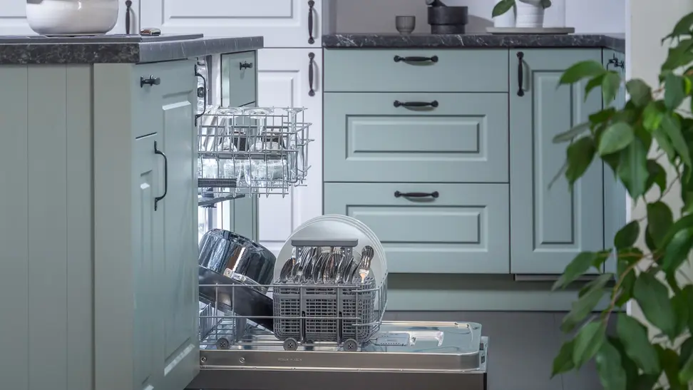 Hisense HUI6220XCUS dishwasher review—Pictured is a shot of the Hisense HUI6220XCUS dishwasher installed into a typical kitchen, from a side angle. Its door is open and its racks have been pulled out slightly. Both racks are stocked with dishes.