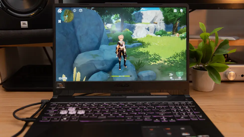 The laptop is on a desk, with a game running on the screen.