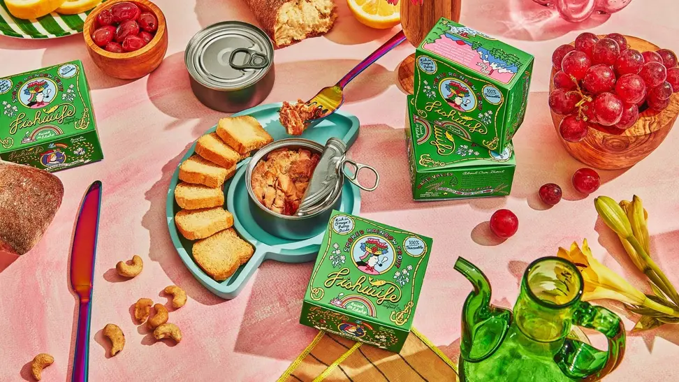 Tinned smoked rainbow trout served with tiny toasts on a teal plate.
