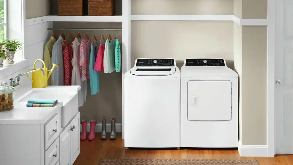 A shot of a homey laundry room. The scene focuses on the Frigidaire FFRE4120SW dryer, which is beside its paired washer, the FFTW4120SW.