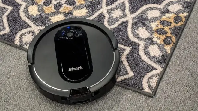 A Shark IQ AV1010AE Robot Vacuum cleaning a carpet.