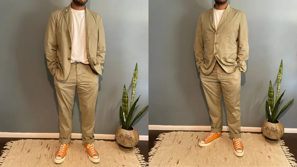 man with hands inside pockets wearing Buck Mason Carry-On Suit and orange Chuck Taylors