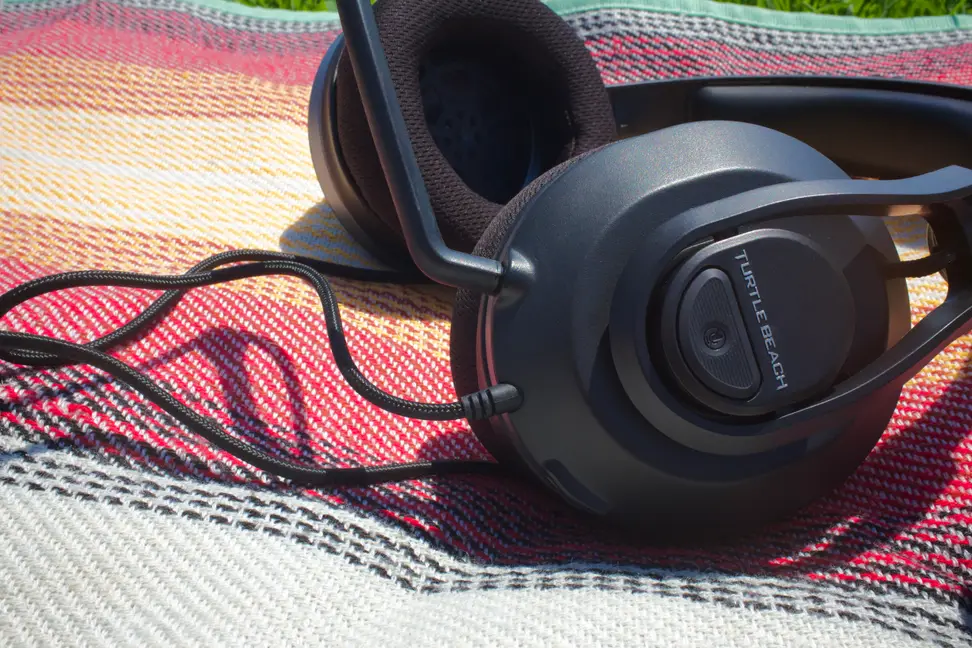 A gaming headset on top of a colorful blanket.