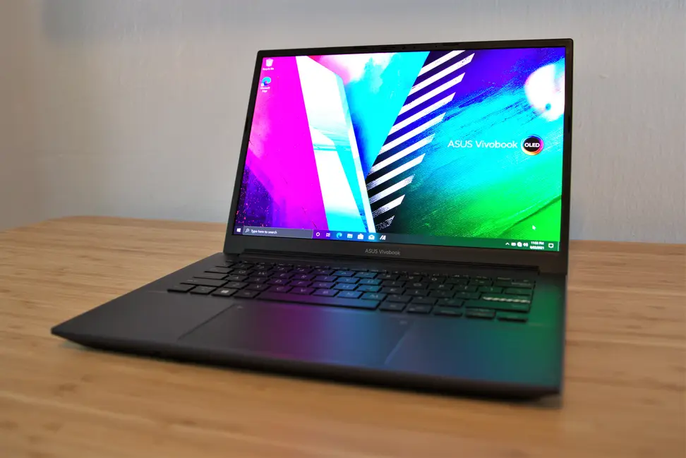 A powered-up, open laptop sitting on top of a desk