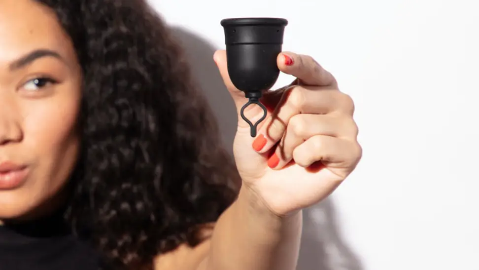 Woman holding Flex menstrual cup.