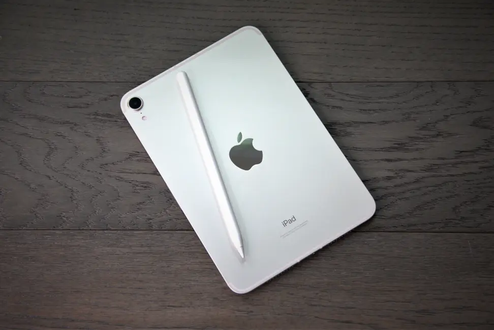 An Apple iPad Mini 6th-gen with Apple Pencil laid on top of it.
