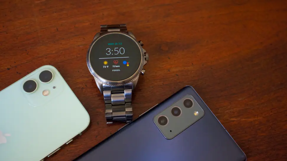 A smartwatch in the middle of two smartphones
