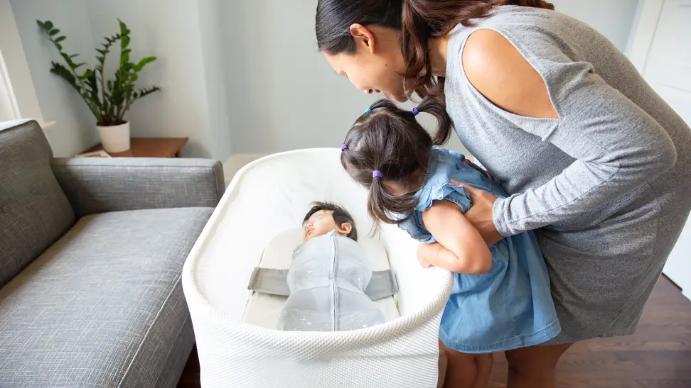 A mother and her children (the smaller of whom is nestled comfortably in a bassinet).