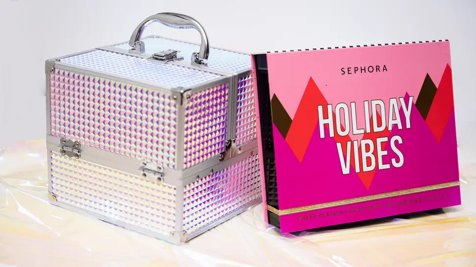 Two makeup gift kits sitting side by side on glittery cellophane.