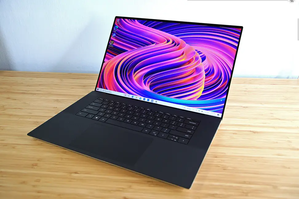 An open and powered on laptop on top of a desk
