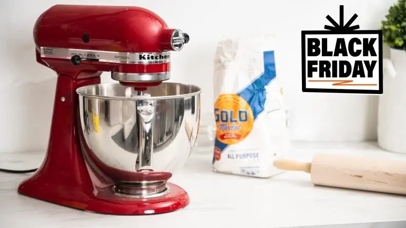 A red KitchenAid stand mixer on a kitchen counter next to baking supplies