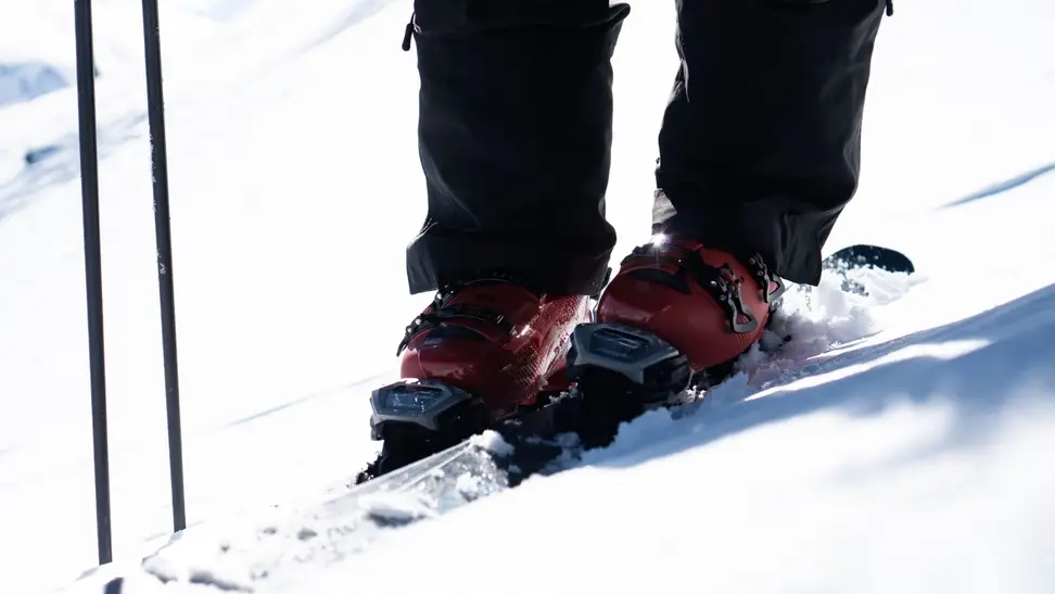 Photo of a pair of Tecnica ski boots in use out on the slopes.