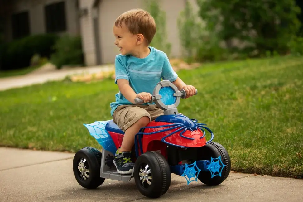A small child enjoys a ride-on toy from Kid Trax.
