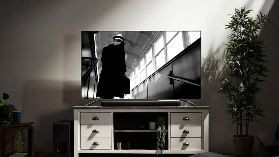 A television and a sound-bar on a TV cabinet