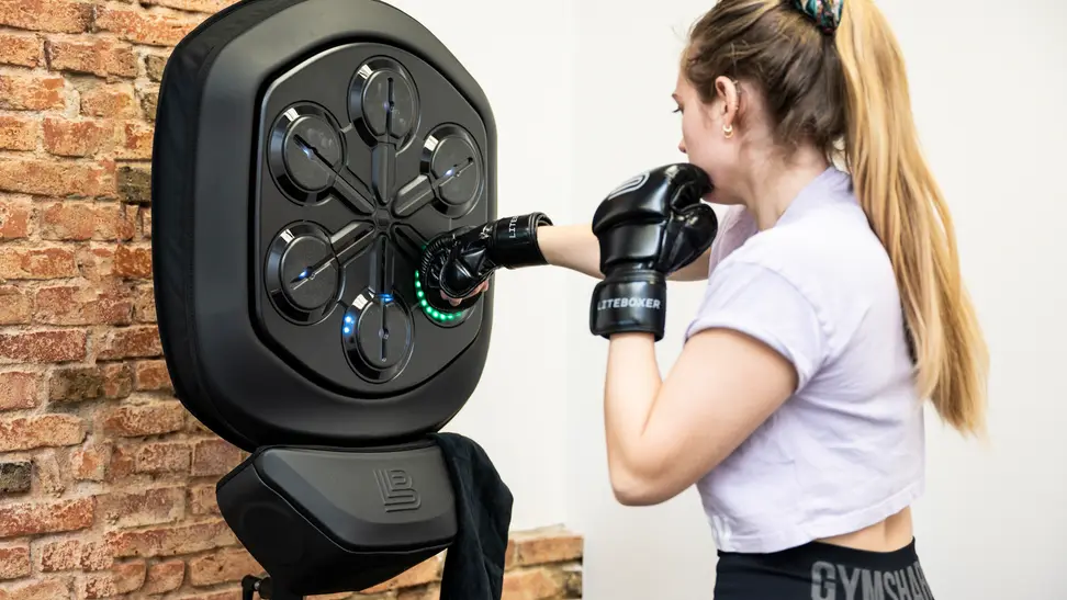 A woman punching the Liteboxer shield.