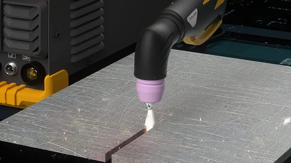 A worker uses a plasma cutter in their workshop.