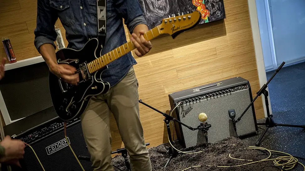 A guy practicing a song in his studio for an upcoming gig.