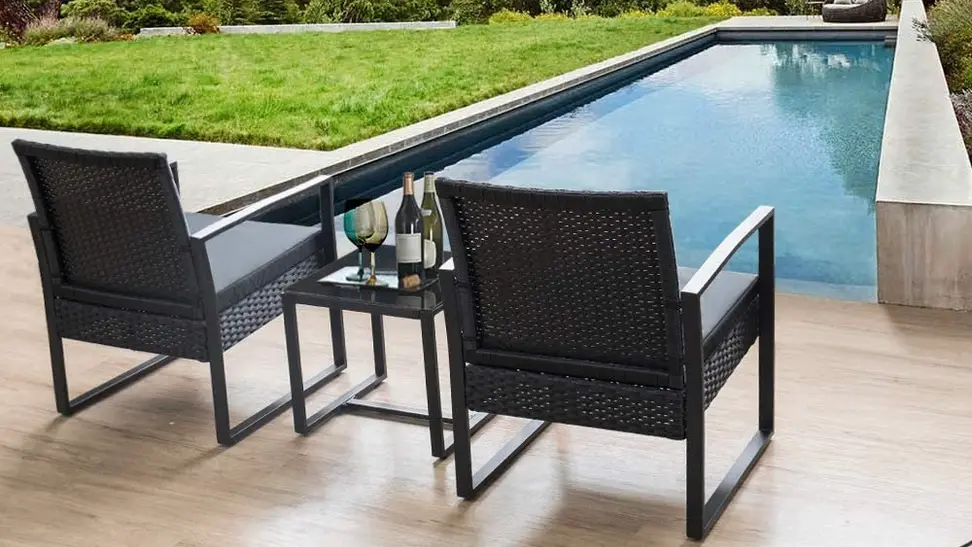 A 3-piece patio set placed in front of an in-ground pool.