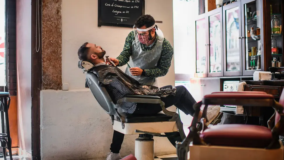 Man getting shaved by a barber