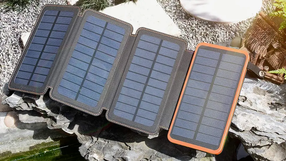 A small, foldable solar charger is on display with four panels, each made up of smaller rectangular cells.