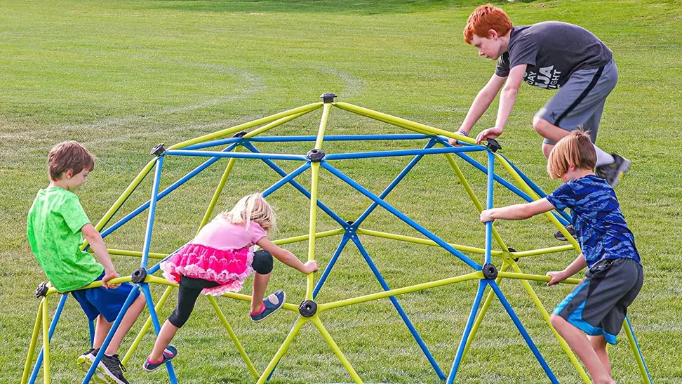 Four children of different ages playing on a jungle gym