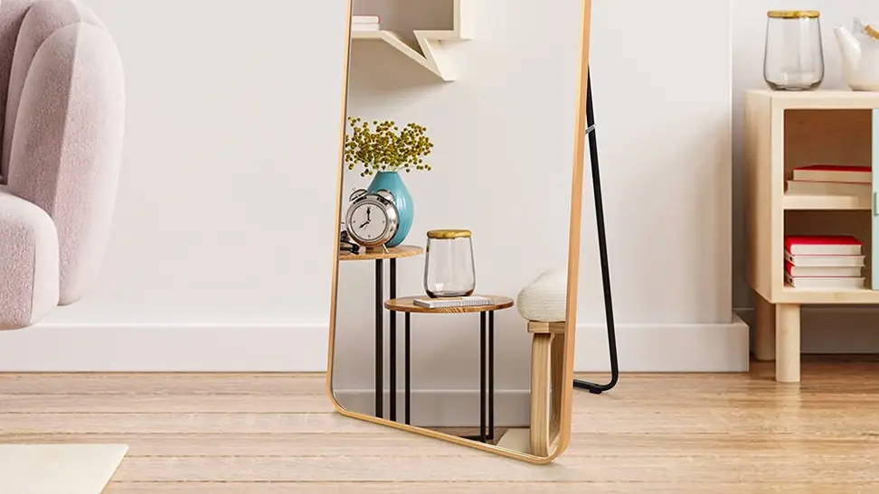 A Zbeivan floor mirror on display in a bedroom; an alarm clock appears in the reflection.