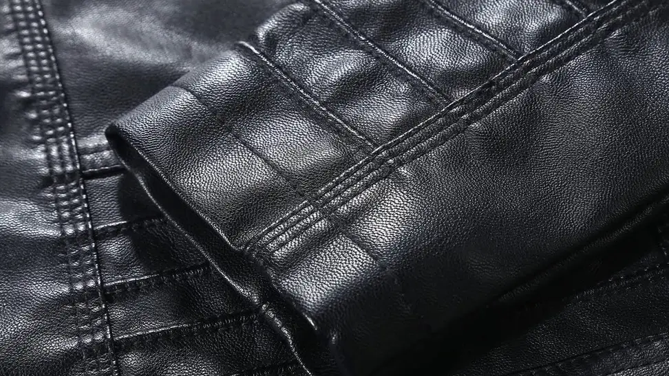 Close-up on a pleated black sleeve, which shows the texture of a Tanming leather jacket.