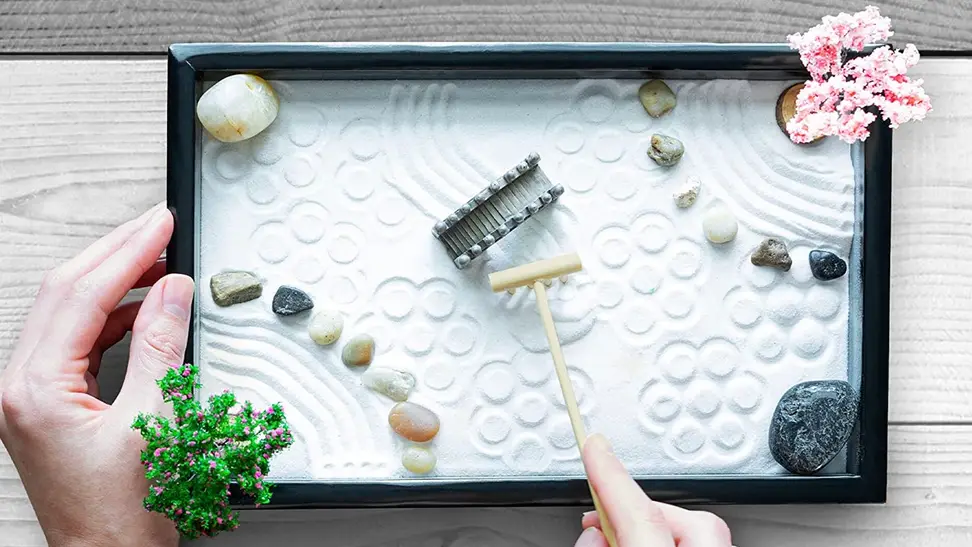 An employee taking a break from work to build a zen garden.