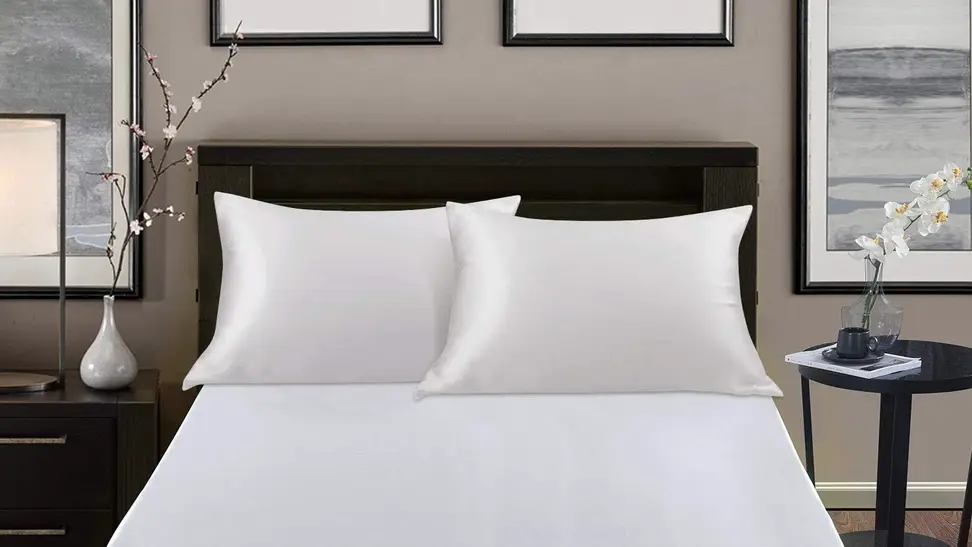 A set of silk pillowcases placed on a bed.