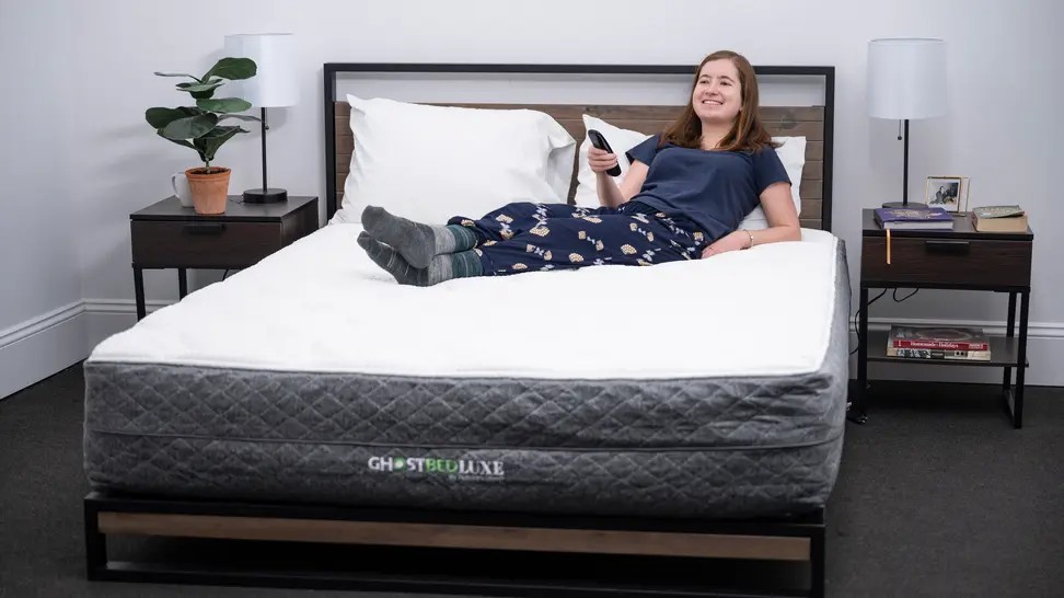 A woman laying on top of the GhostBed Luxe.