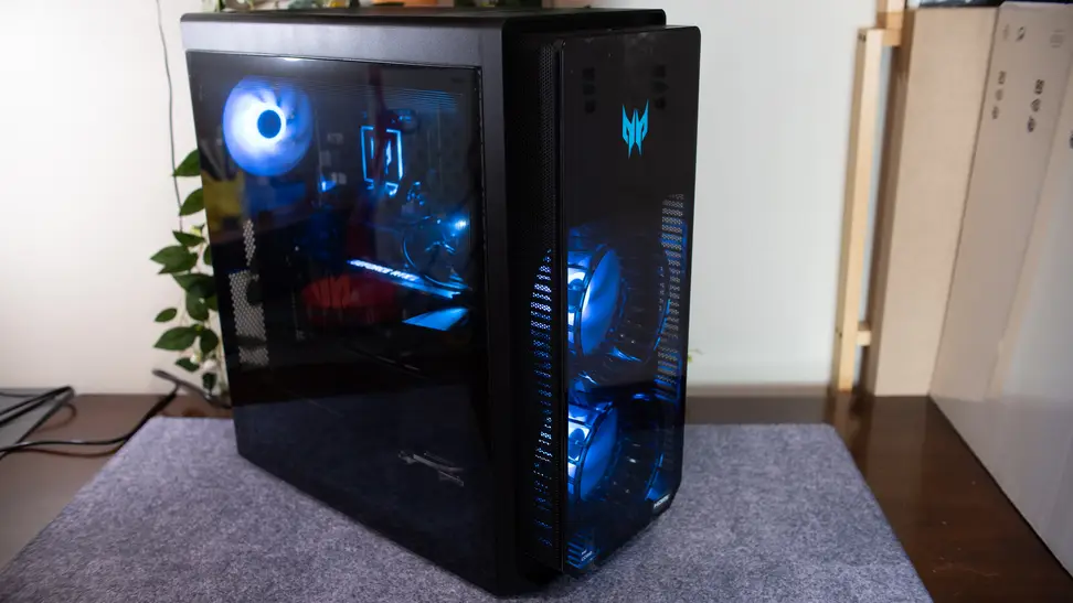 The desktop is on a desk, turned on and glowing blue.