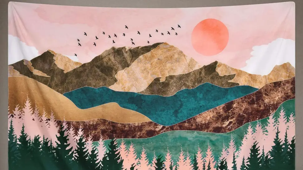 A wall tapestry with a mountainous landscape hanging on a wall.