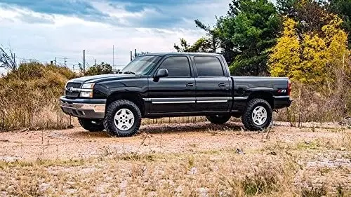 A lifted truck parked in a backyard.