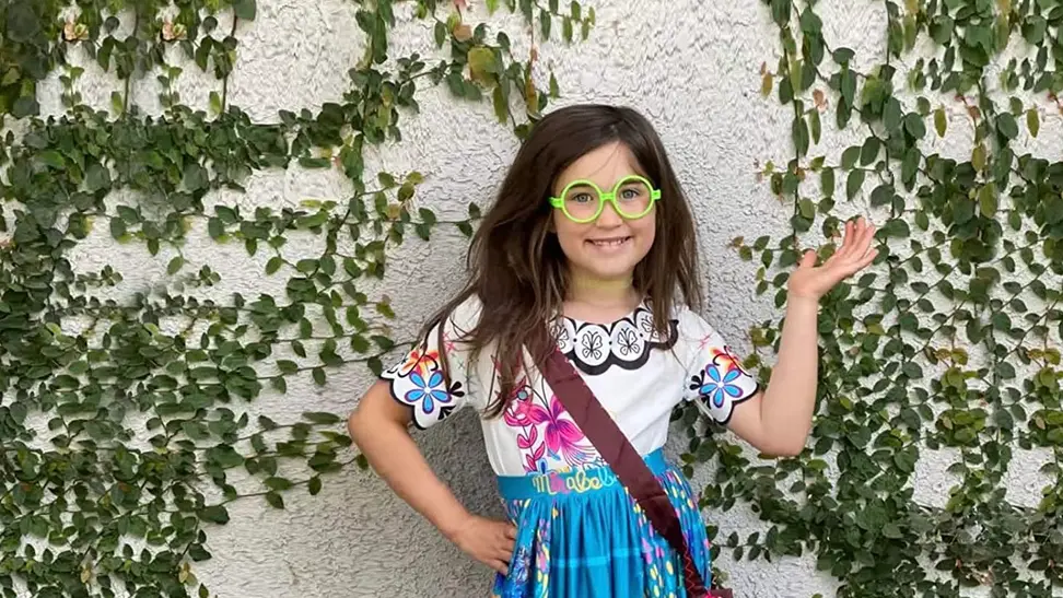 A girl wearing her halloween costume to a family party.