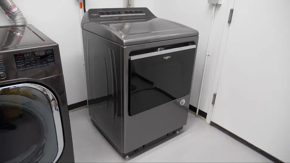 A gray Whirlpool dryer placed in a laundry room.
