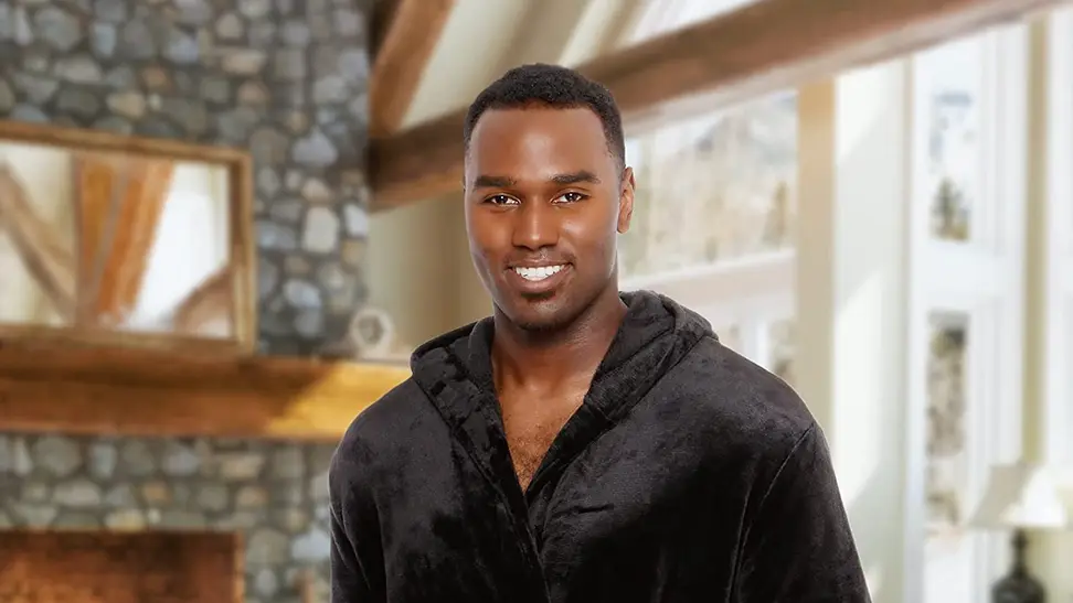 A person in a cozy bathrobe enjoys their morning coffee. A fireplace is visible in the background.