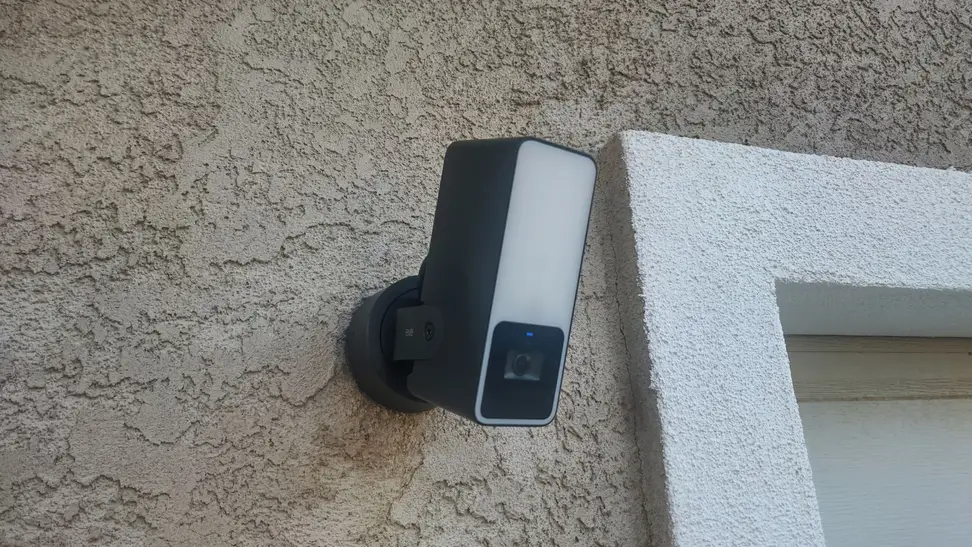 The Eve Cam Outdoor smart floodlight hangs near a residential garage