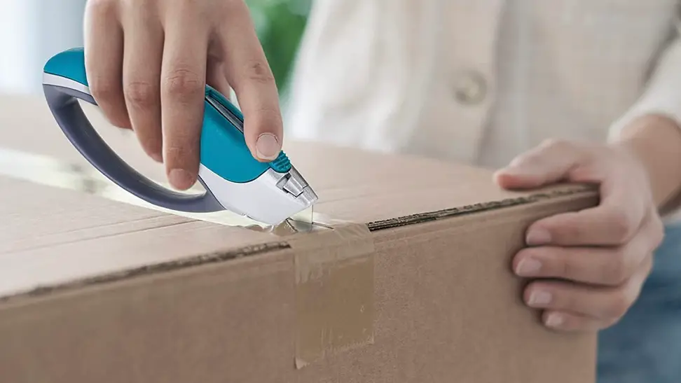 A woman using her box cutter to open packages.