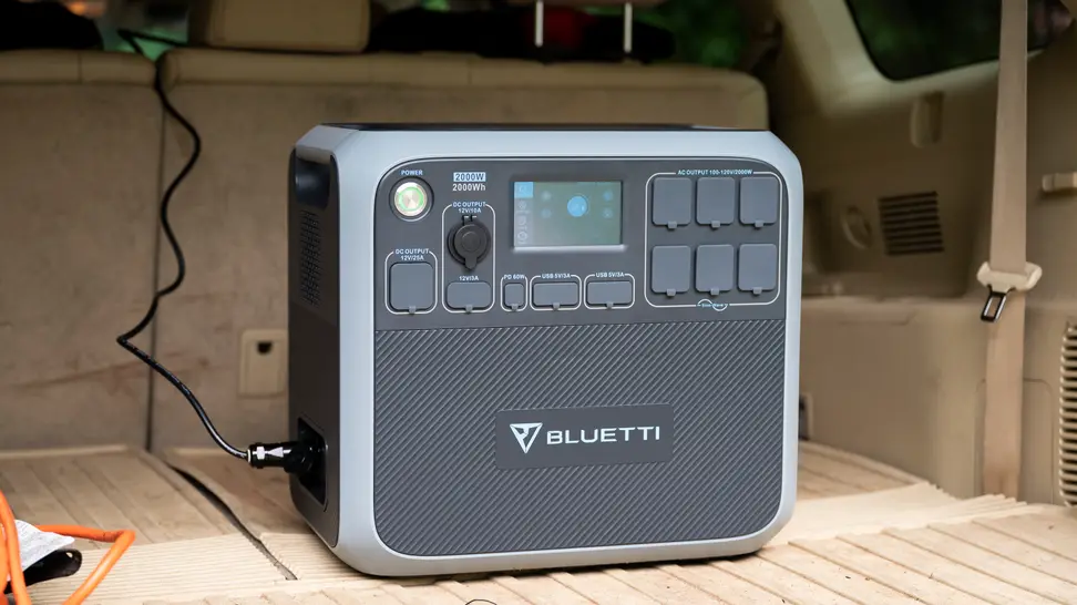 A solar powered generator sits in a car trunk.