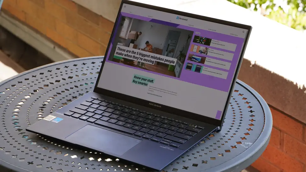 An Asus laptop sits on a patio table outside.