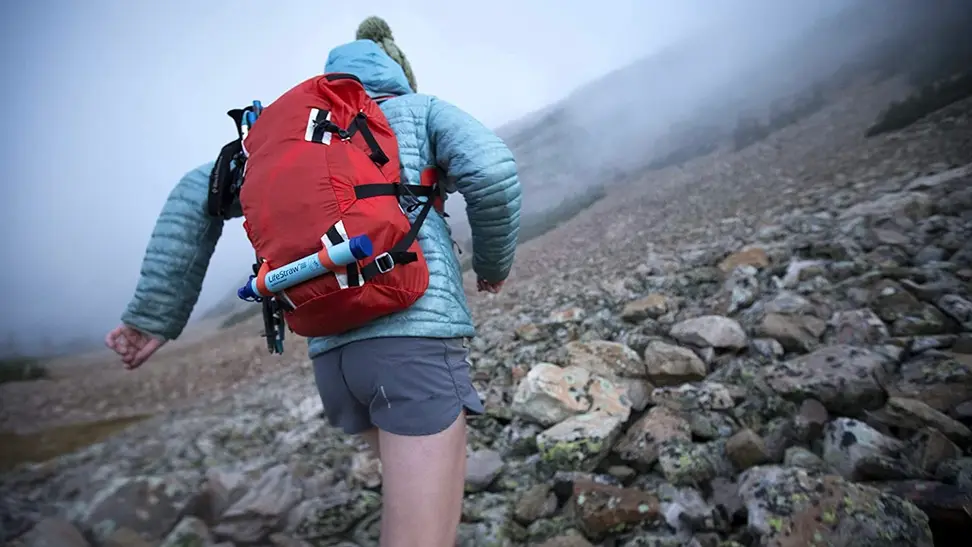 A girl hiking with her portable water filter.