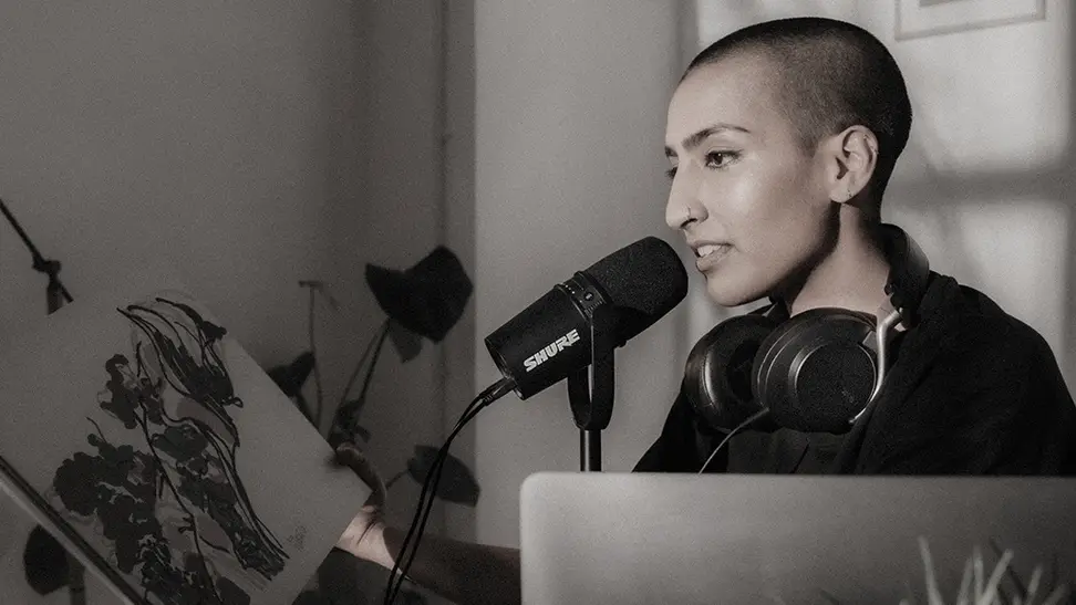 A model demonstrates the use of the Shure MV7 podcasting microphone.