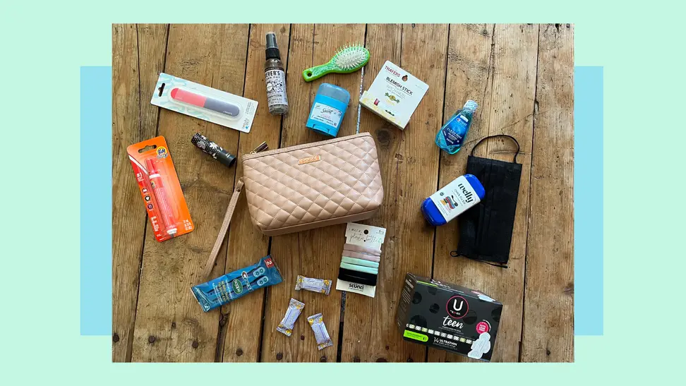 Small toiletry bag with assorted hygiene products scattered all around on tabletop surface.