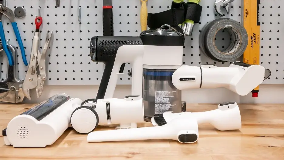Tineco S15 Pet with its brush head, mini power brush, crevice and dusting tool on a workbench