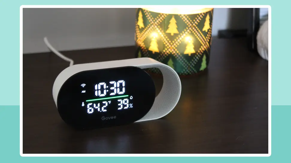 The Govee Smart Air Quality Monitor sits on a nightstand with the time and data displayed on a digital screen