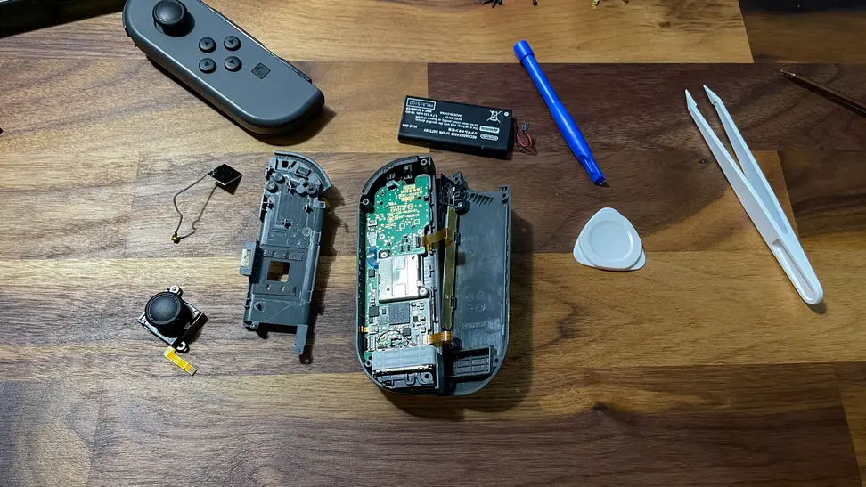 A pair of Nintendo Switch Joy-cons opened and being worked on to fix stick drift.