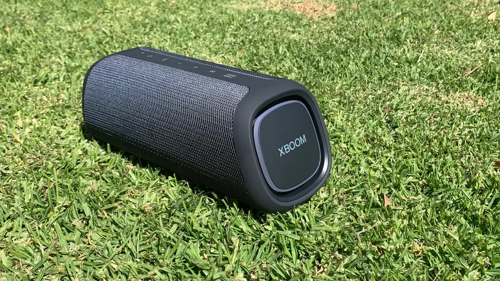A black LG XBoom Go on a patch of grass.